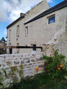 ein Backsteingebäude mit einer Steinmauer und einer Blume in der Unterkunft Le Clos du Marronnier in Cully