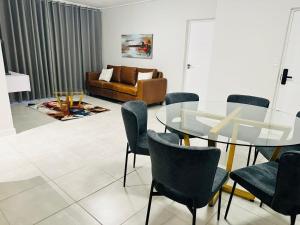 a living room with a glass table and chairs at Ballito Hills Lifestyle Estate in Ballito
