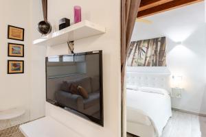 a bedroom with a mirror and a bed and a couch at Suite Martini al Castello in Cagliari