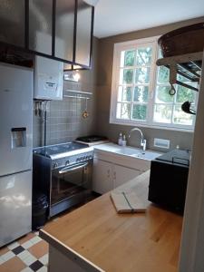 a kitchen with a stainless steel stove and a sink at Maison familiale Cabourg in Cabourg
