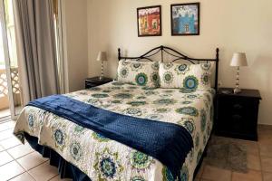 1 dormitorio con 1 cama con edredón azul y blanco en Departamento de lujo con vista al MAR y campo de GOLF, en Barrón