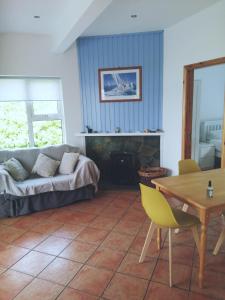 ein Wohnzimmer mit einem Sofa und einem Tisch in der Unterkunft Carolina Cottage in Buncrana