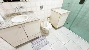 a bathroom with a sink and a toilet and a shower at Fragata Beach House - A duas quadras do Mar in Guaratuba +26 photos