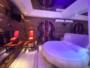 a room with a bed and chairs and a tv at Camelot Motel by Drops in São Leopoldo