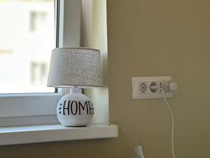 Una lámpara en el alféizar de una ventana con la palabra "hogar" escrita en ella. en Stefan's Place en Victoria