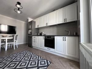 a kitchen with white cabinets and a dining table at Stefan's Place in Victoria