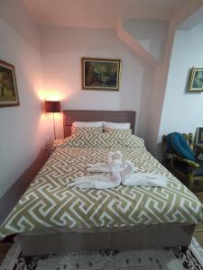 ein Schlafzimmer mit einem Bett mit zwei darauf liegenden Puppen in der Unterkunft In Apartments AirPort in Mitrovići