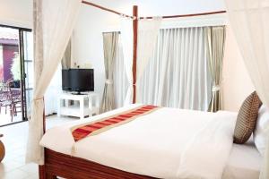 a bedroom with a bed and a tv in a room at Villa Raya Resort Private Pool Villas in Pattaya North