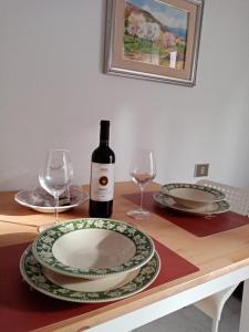 una mesa con dos copas y una botella de vino en Daro's apartment, en Selargius