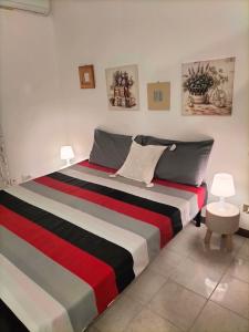 1 dormitorio con 1 cama con manta roja blanca y negra en Daro's apartment, en Selargius