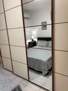 a mirror in a bedroom with a bed at Daro's apartment in Selargius
