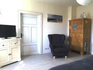 sala de estar con silla y TV en Ferienhaus mit Terrasse und Kamin, en Karnin