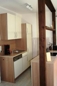 una cocina con armarios blancos y fregadero en Ferienhaus mit Terrasse und Kamin, en Karnin