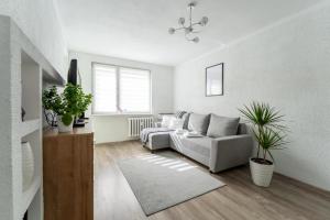 a living room with a couch and some plants at Apartament Gold - 2 osobne sypialnie z balkonem - SpaceApart in Jelenia Góra