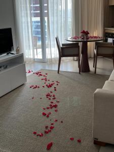 uma pilha de pétalas vermelhas no chão de uma sala de estar em Estanconfor Vista Mar em Santos em Santos