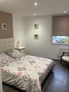 a bedroom with a bed and a window and a chair at L'Oreade in Amfreville-sur-Iton