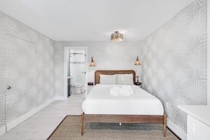 a bedroom with a white bed with a wooden headboard at Caloosa Retreat- 2BR at Palmview Inn Sanibel in Sanibel