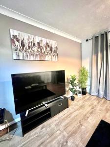 a living room with a large flat screen tv at Great Value for Contractors, Groups, Families Stay Call Today MLR Housing Short Lets & Serviced Accommodation Barking in Dagenham