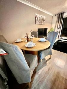 a dining room table with chairs and a wooden table at Great Value for Contractors, Groups, Families Stay Call Today MLR Housing Short Lets & Serviced Accommodation Barking in Dagenham