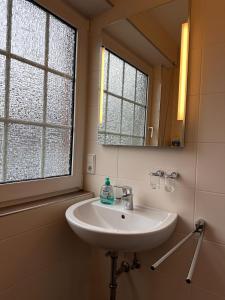 a bathroom with a sink and a mirror at Ferienwohnung Norddeich: Gemütliche Rückzugsoase für 2-4 Personen in Norden