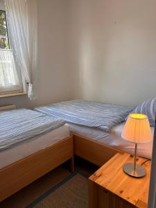 a bedroom with two beds and a table with a lamp at Ferienwohnung Norddeich: Gemütliche Rückzugsoase für 2-4 Personen in Norden