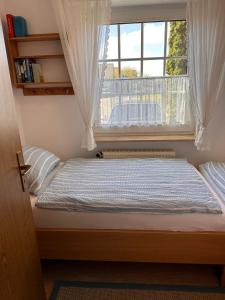 a bed in a room with a window at Ferienwohnung Norddeich: Gemütliche Rückzugsoase für 2-4 Personen in Norden