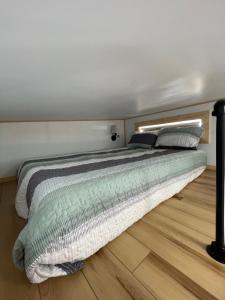 uma cama num quarto com piso em madeira em The Tennessee Tiny House em Sevierville