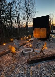 einer Gruppe von Stühlen, einem Tisch und einer Feuerstelle in der Unterkunft The Tennessee Tiny House in Sevierville