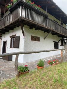 ein Haus mit einem Balkon und einigen Pflanzen und Blumen in der Unterkunft Baita Irma - Miniappartamento in Madonna di Campiglio