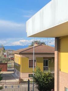a yellow house with mountains in the background at 410 Reasons For Back in Cerea