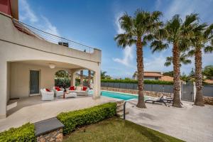 a backyard with a swimming pool and palm trees at Villa Jacqueline con piscina privata 8 posti letto in Scopello