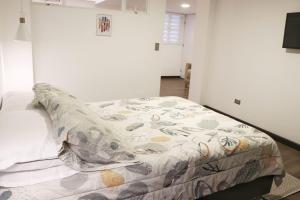 Un dormitorio con una cama con una manta. en Atrizapartaestudio/102/moderno/norte/wifi en Pasto