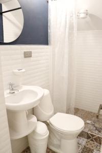 ein weißes Bad mit einem WC und einem Waschbecken in der Unterkunft Atrizapartaestudio/102/moderno/norte/wifi in Pasto