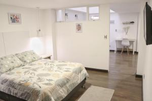ein Schlafzimmer mit einem Bett und einem großen Kühlschrank in der Unterkunft Atrizapartaestudio/102/moderno/norte/wifi in Pasto