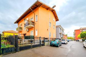 una casa naranja con autos estacionados frente a ella en [Rho-Fiera Milano] Romantic House, en Pero