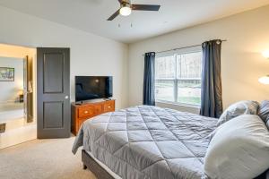 a bedroom with a bed and a flat screen tv at Lakefront Fredericksburg Home with Deck and Fire Pits! in Fredericksburg