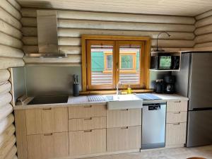 a kitchen with a sink and a refrigerator at Dzikie Gąski in Gąski