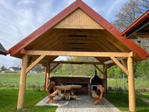 a wooden pavilion with a table and a bottle of wine at Dzikie Gąski in Gąski