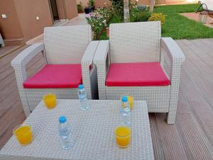 two wicker chairs with water bottles on a table at Villa Treasure of Marrakech in Marrakech