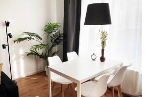 - une table à manger blanche avec des chaises blanches et une plante dans l'établissement Großzügiges City-Apartment in Mönchengladbach, à Mönchengladbach