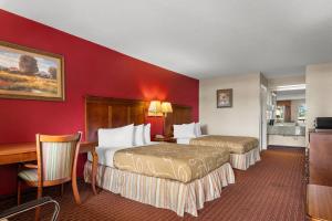 a hotel room with two beds and a desk at Americas Best Value Inn-Montezuma in Montezuma