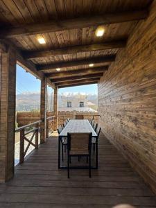 una terrazza in legno con tavolo e sedie. di Swiss House Dilijan a Dilijan