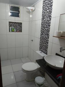 een witte badkamer met een toilet en een wastafel bij Casa Girassol in Prado