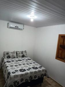 een slaapkamer met een bed met een zwart-witte deken bij Casa Girassol in Prado