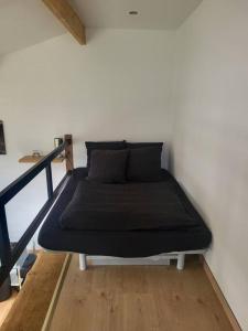ein Bett in einem Zimmer neben einer Wand in der Unterkunft Le studio in Béhoust