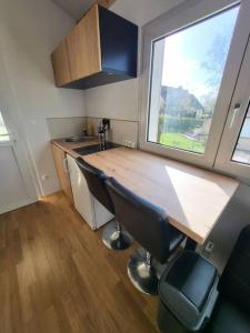 eine Küche mit Holztheke und großem Fenster in der Unterkunft Le studio in Béhoust + 3 Fotos