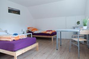 a room with two beds and a table and a table at Monteuerunterkunft - Flexibel und Modern!- NEU in Laichingen