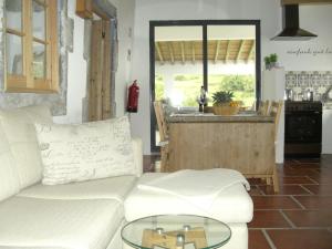 a living room with a white couch and a table at Ferienhaus mit Meerblick, Whirlpool und viel Privatsphäre in Nordeste