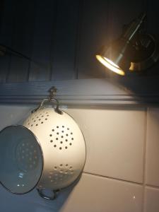 a bathroom sink with a strainer and a light at Schönes Appartement in Zierzow mit Grill, Terrasse und Garten in Sietow