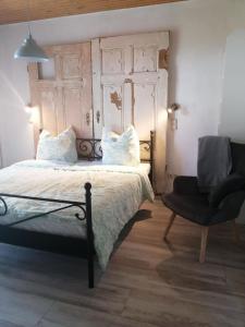 a bedroom with a bed and a chair at Schönes Appartement in Zierzow mit Grill, Terrasse und Garten in Sietow